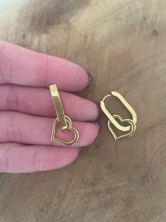 Détail gros plan boucles d’oreilles anneaux et breloque coeur doré