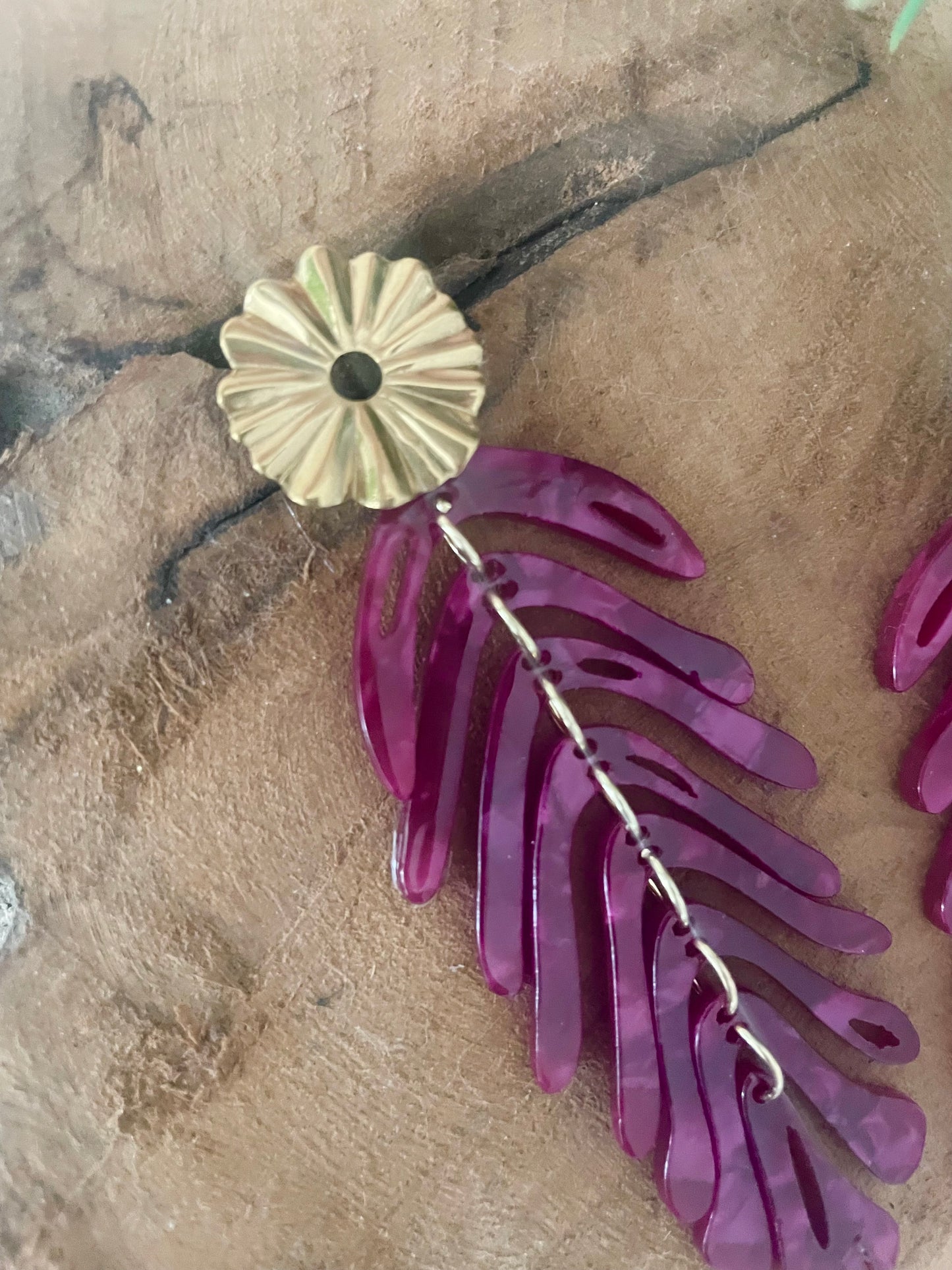 Gros plan clou fleur strié et grand pendentif feuille bordeaux acrylique