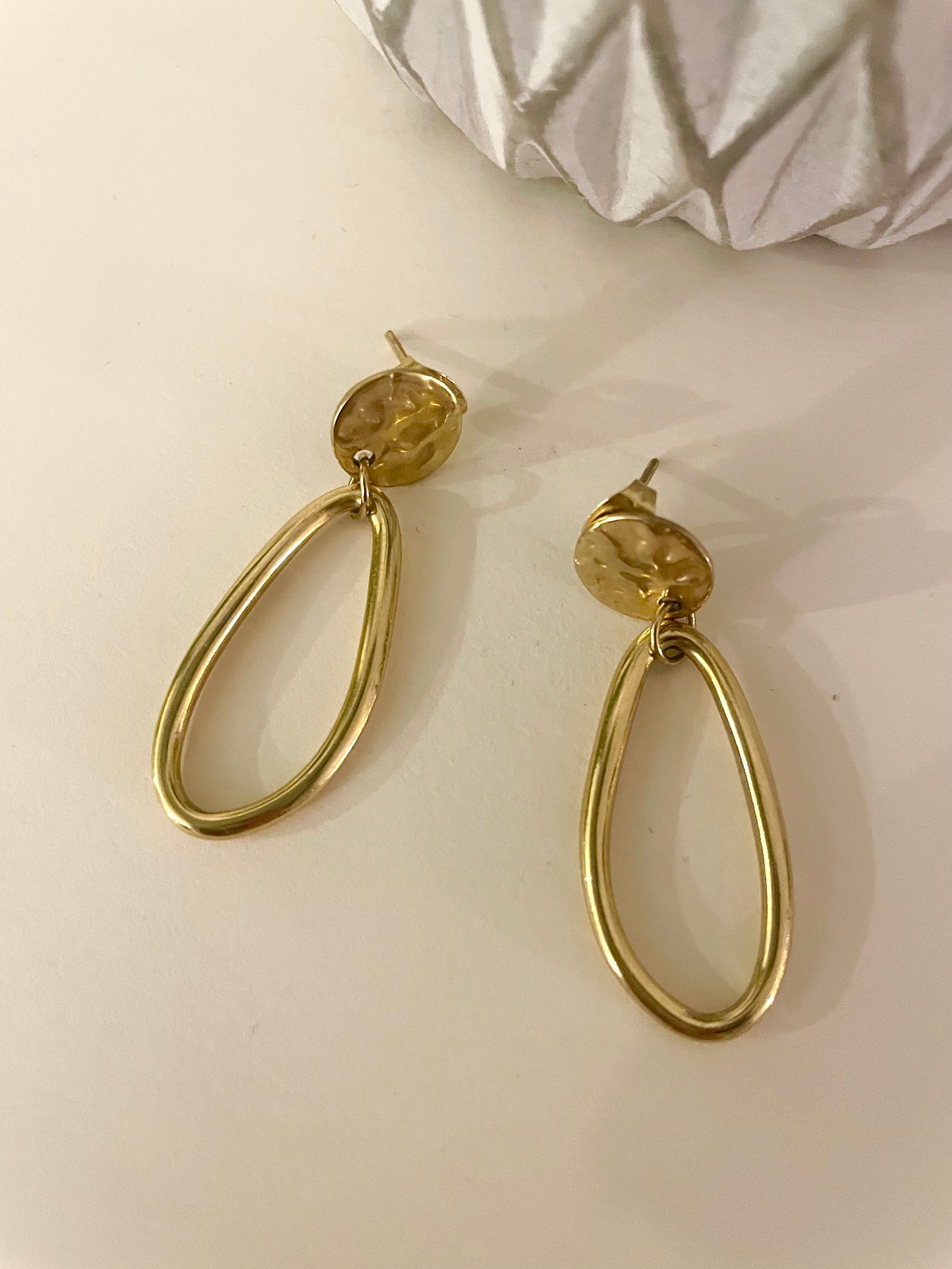 Boucles clou martelé doré et pendentif asymétrique lisse fond blanc