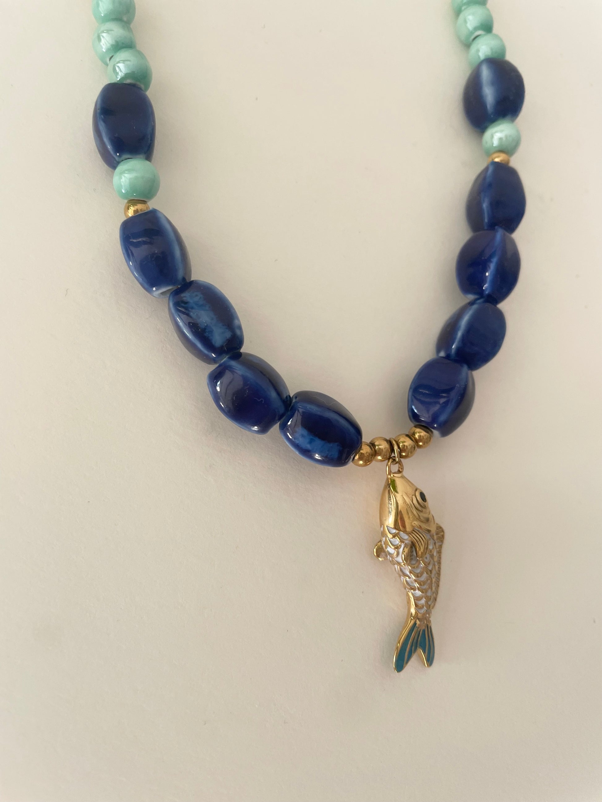 Détail pendentif poisson acier inoxydable doré touches bleues