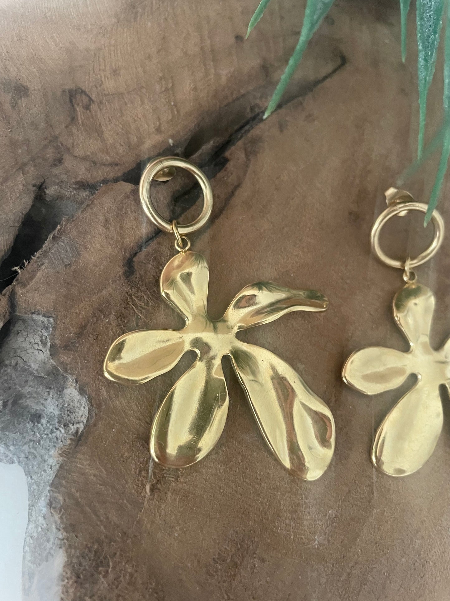 Gros plan boucles d’oreilles grosses fleurs dorées tendance 2026