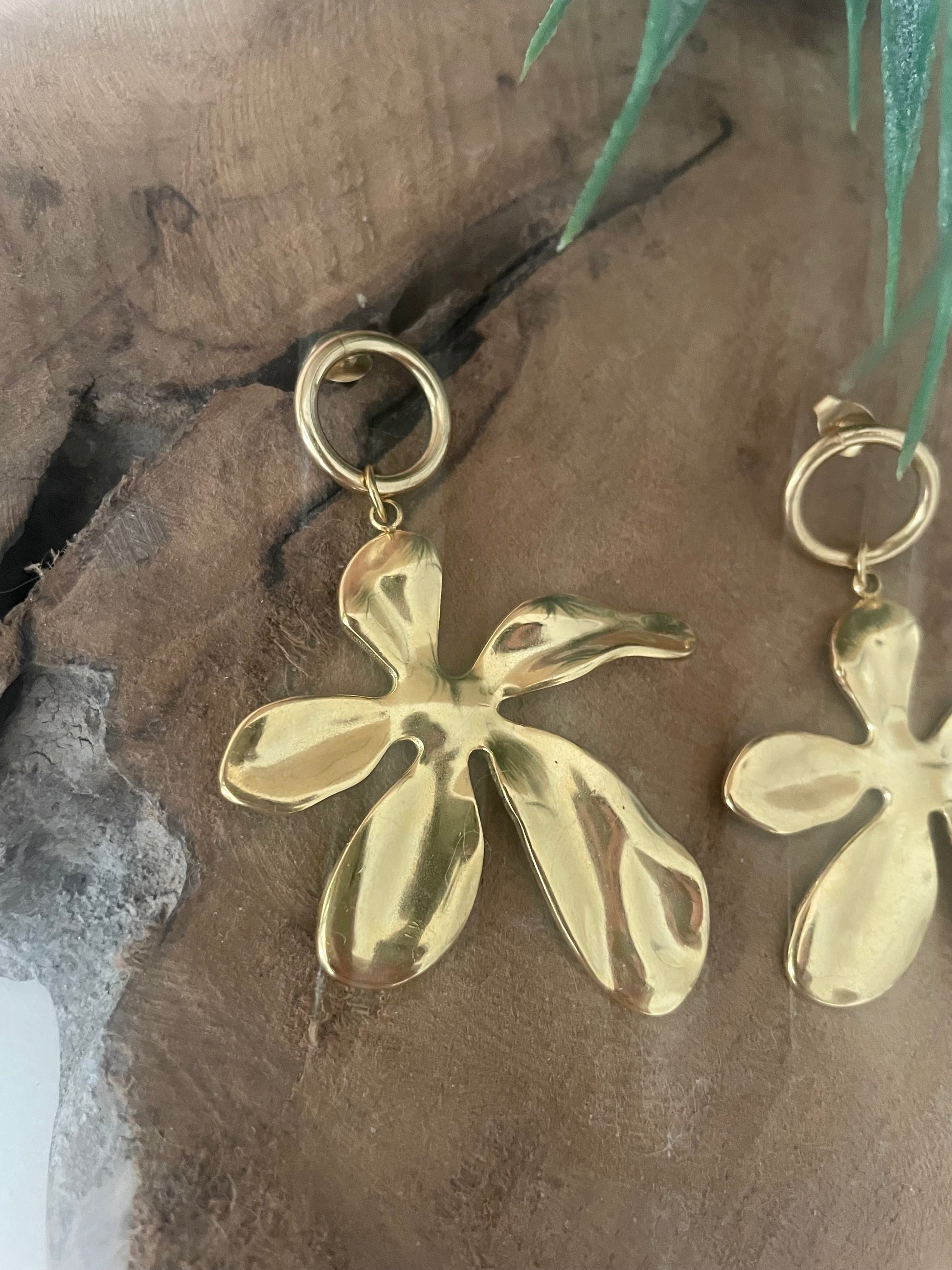 Gros plan boucles d’oreilles grosses fleurs dorées tendance 2026