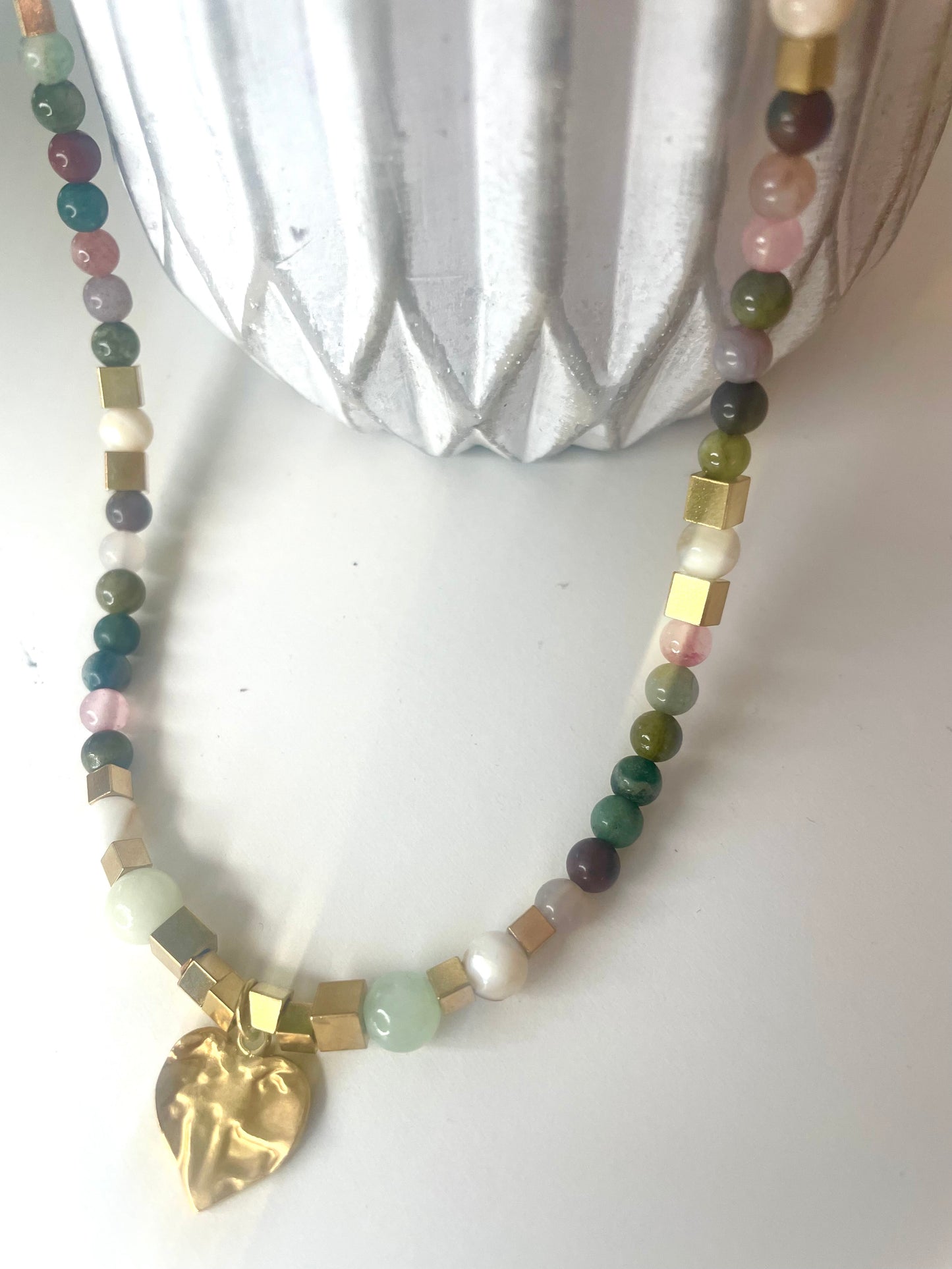 Gros plan pendentif coeur martelé collier Gisèle pierres vert rose