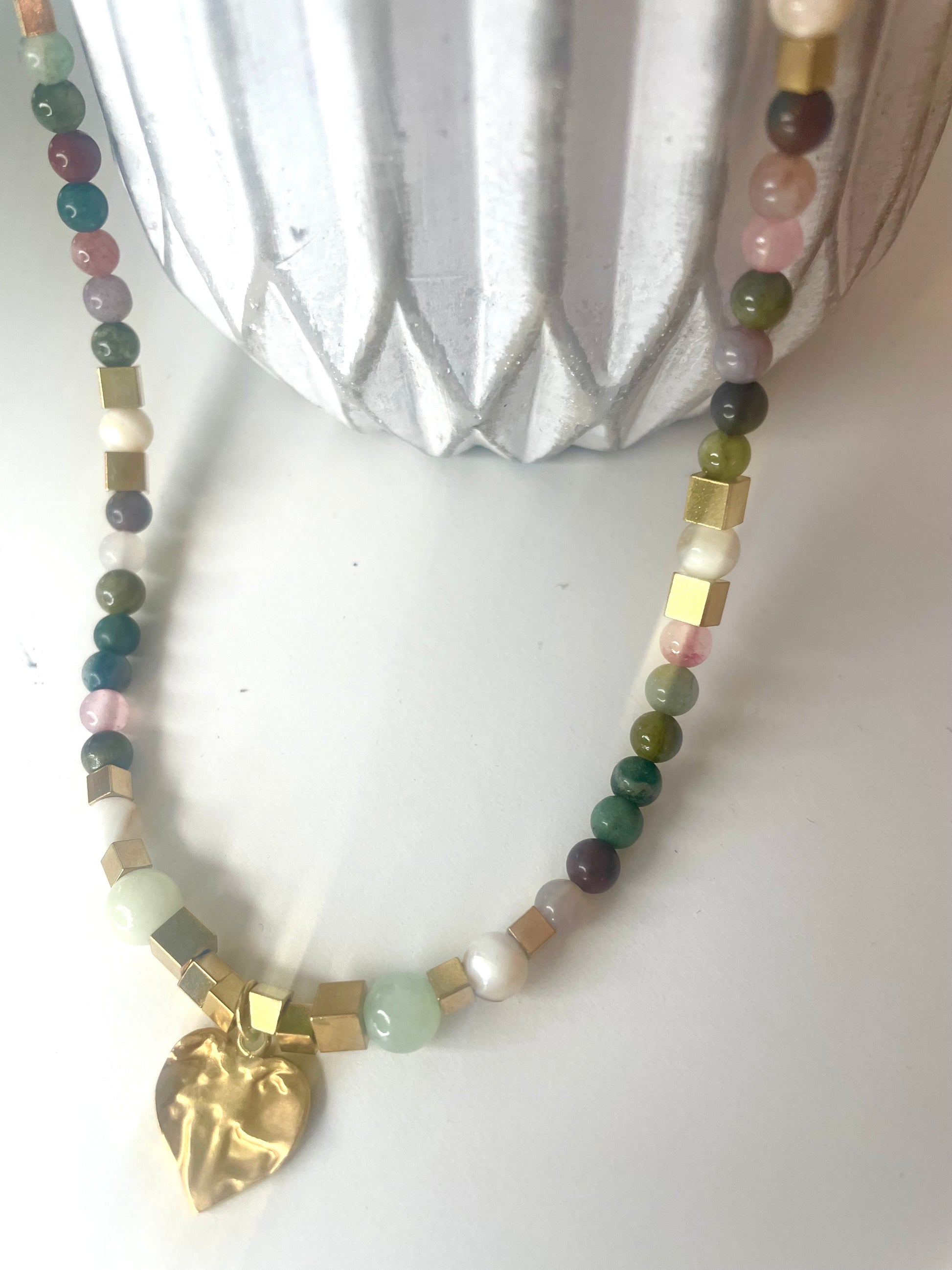 Gros plan pendentif coeur martelé collier Gisèle pierres vert rose