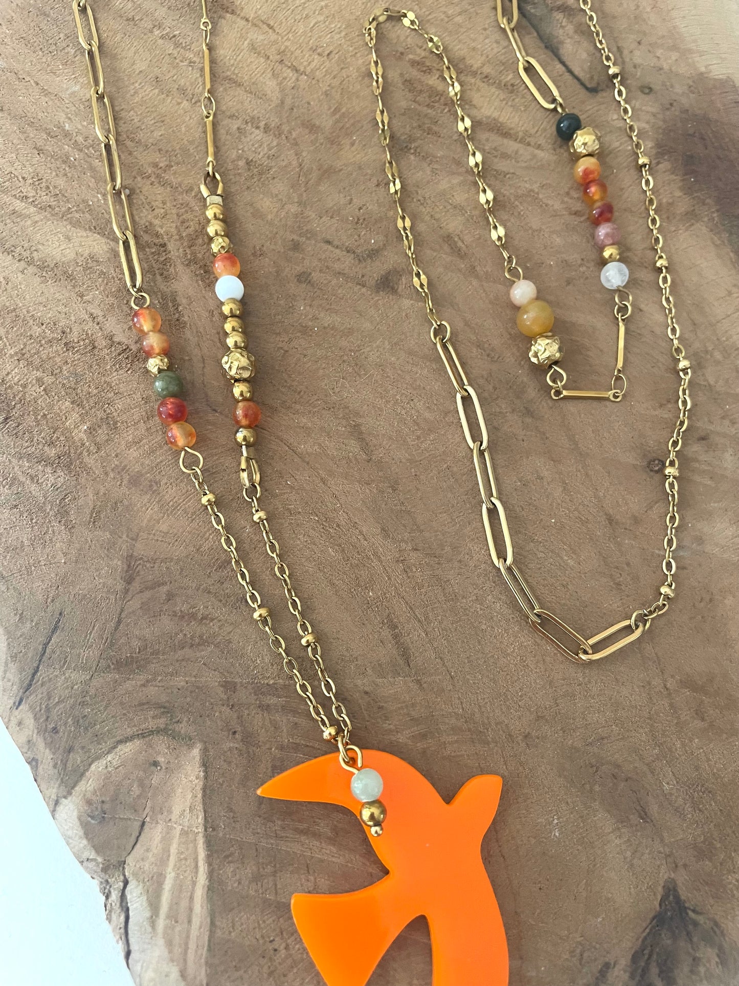 Gros plan zoom pendentif orange oiseau acrylique et pierres naturelles sautoir liberté