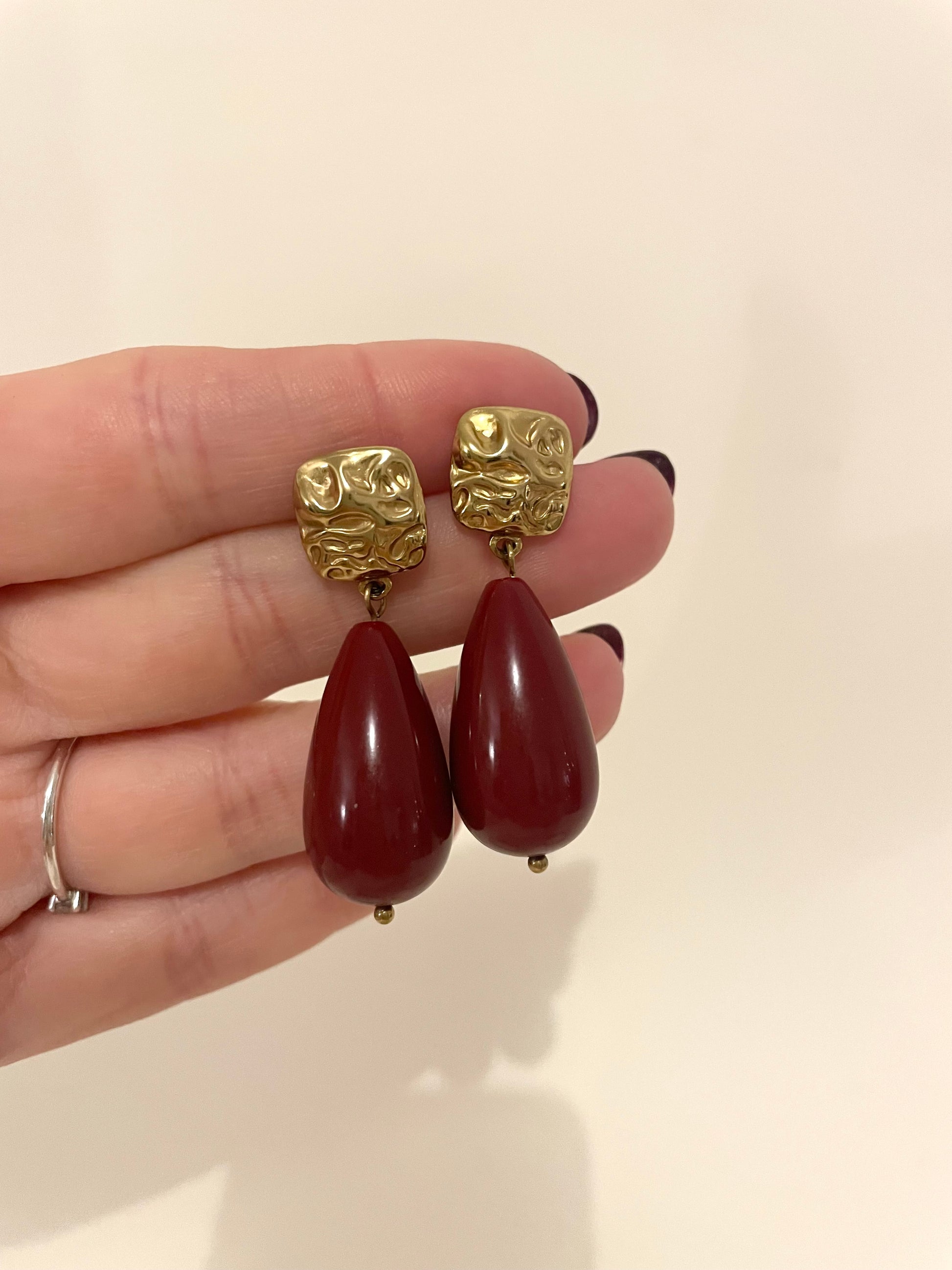 Autre angle de face boucles d’oreilles gouttes bordeaux en résine et acier inoxydable doré 