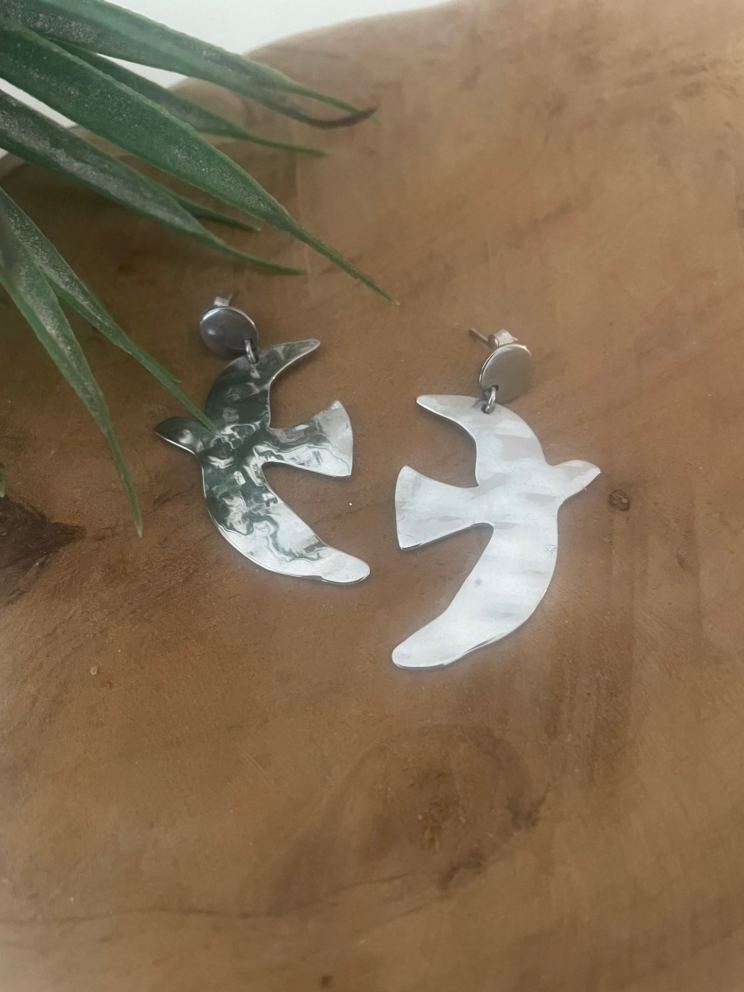 détail reflets boucles argent oiseaux fond bois