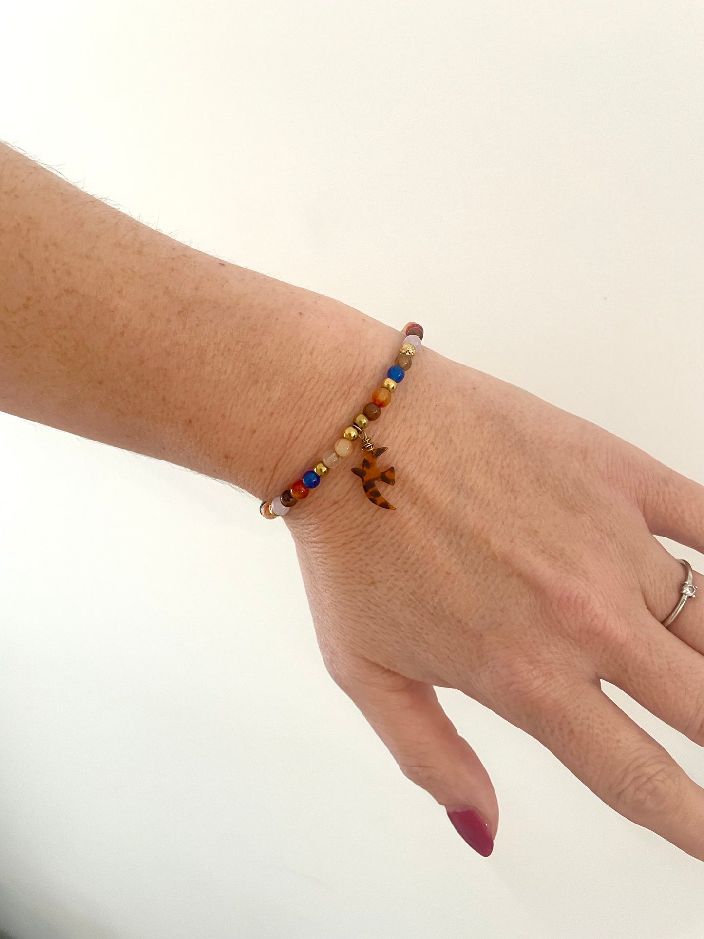 Bracelet thème LIBERTÉ doré breloque oiseau léopard et pierres naturelles orange-marron-bleu