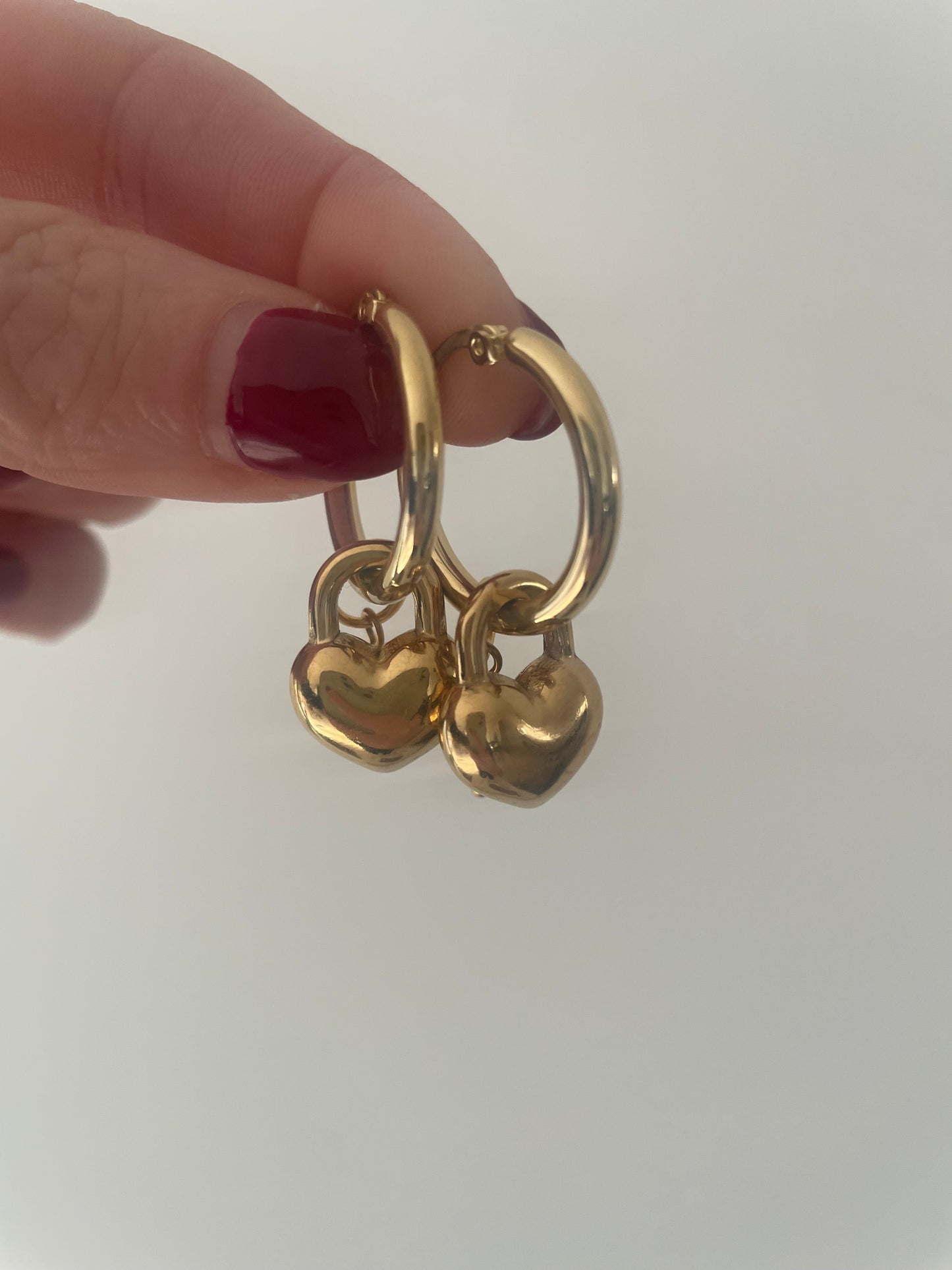 Gros plan boucles anneaux dorés avec breloque coeur et perle d’eau douce monté à la main