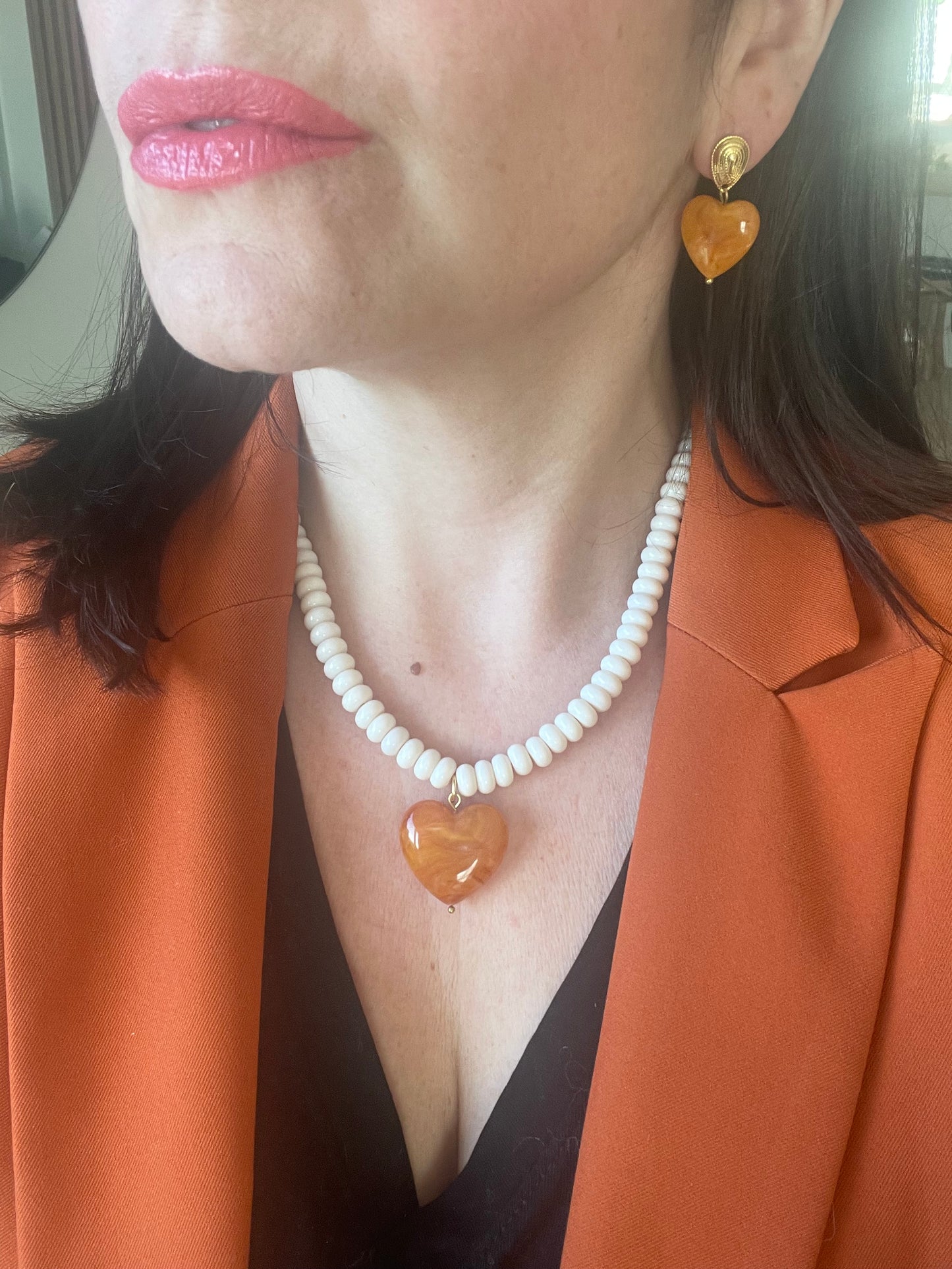 autre angle porté parure collier ivoire et orange ambré coeuravec boucles oreilles coeur