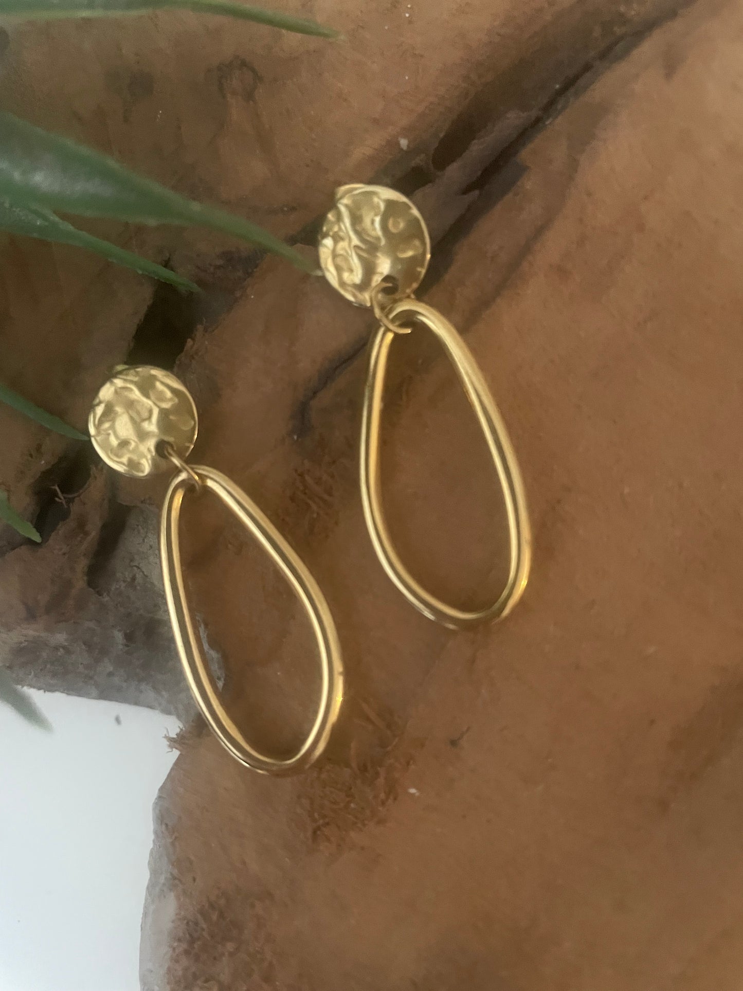 Détail clou martelé doré boucles pendentif ovale lisse asymétrique