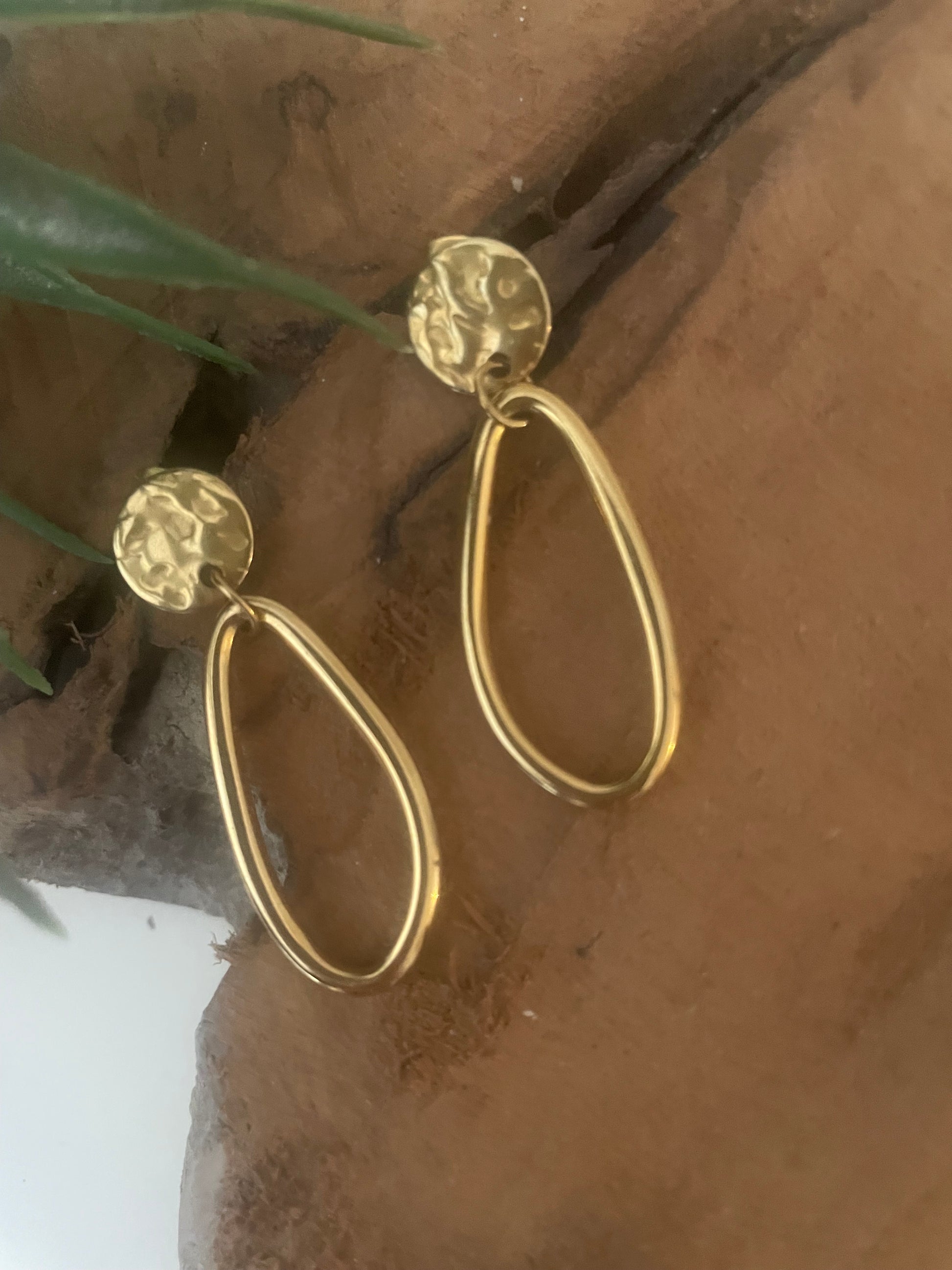 Détail clou martelé doré boucles pendentif ovale lisse asymétrique