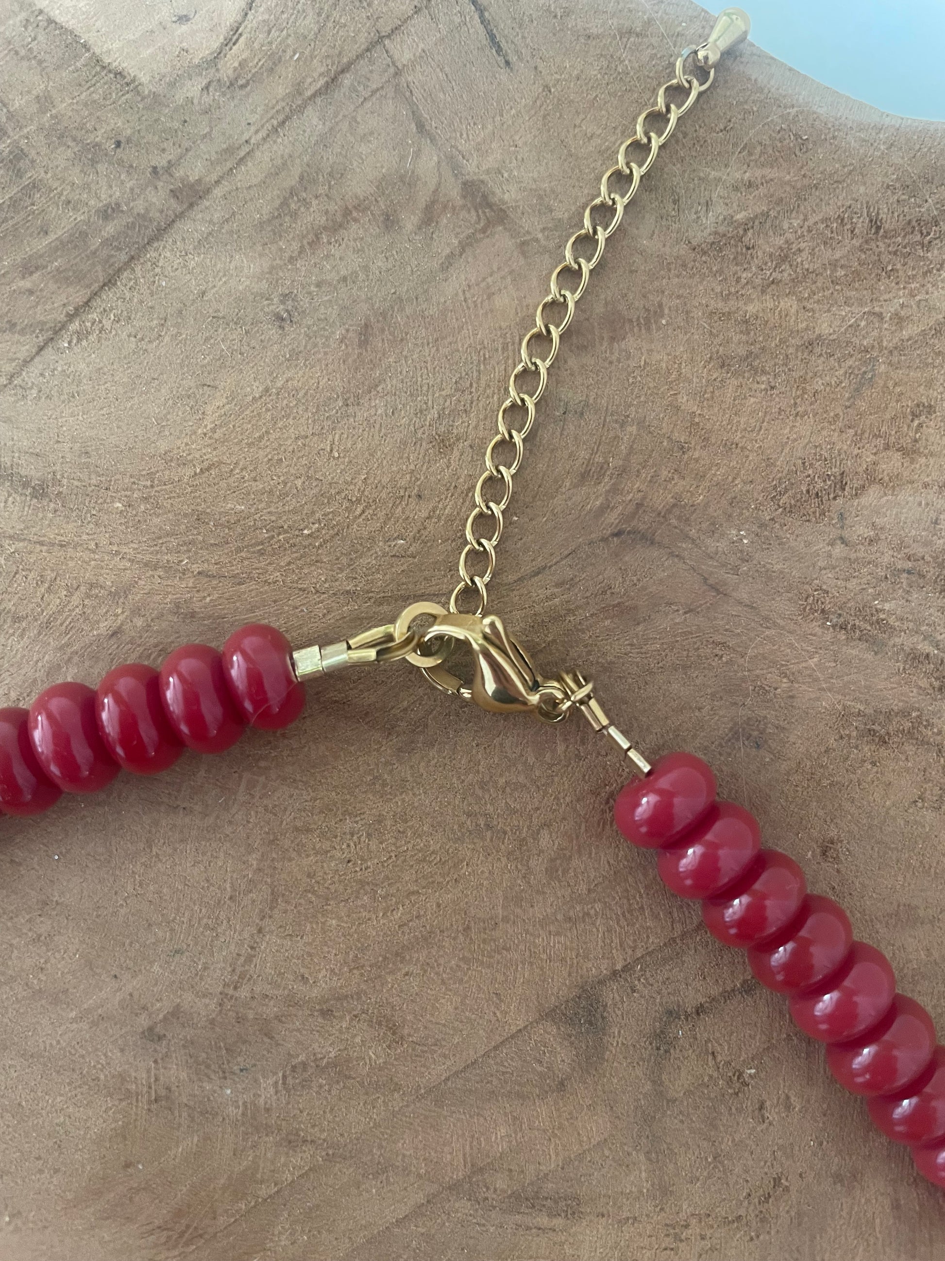 Détail fermoir doré acier inoxydable collier perles heishi de verre bordeaux