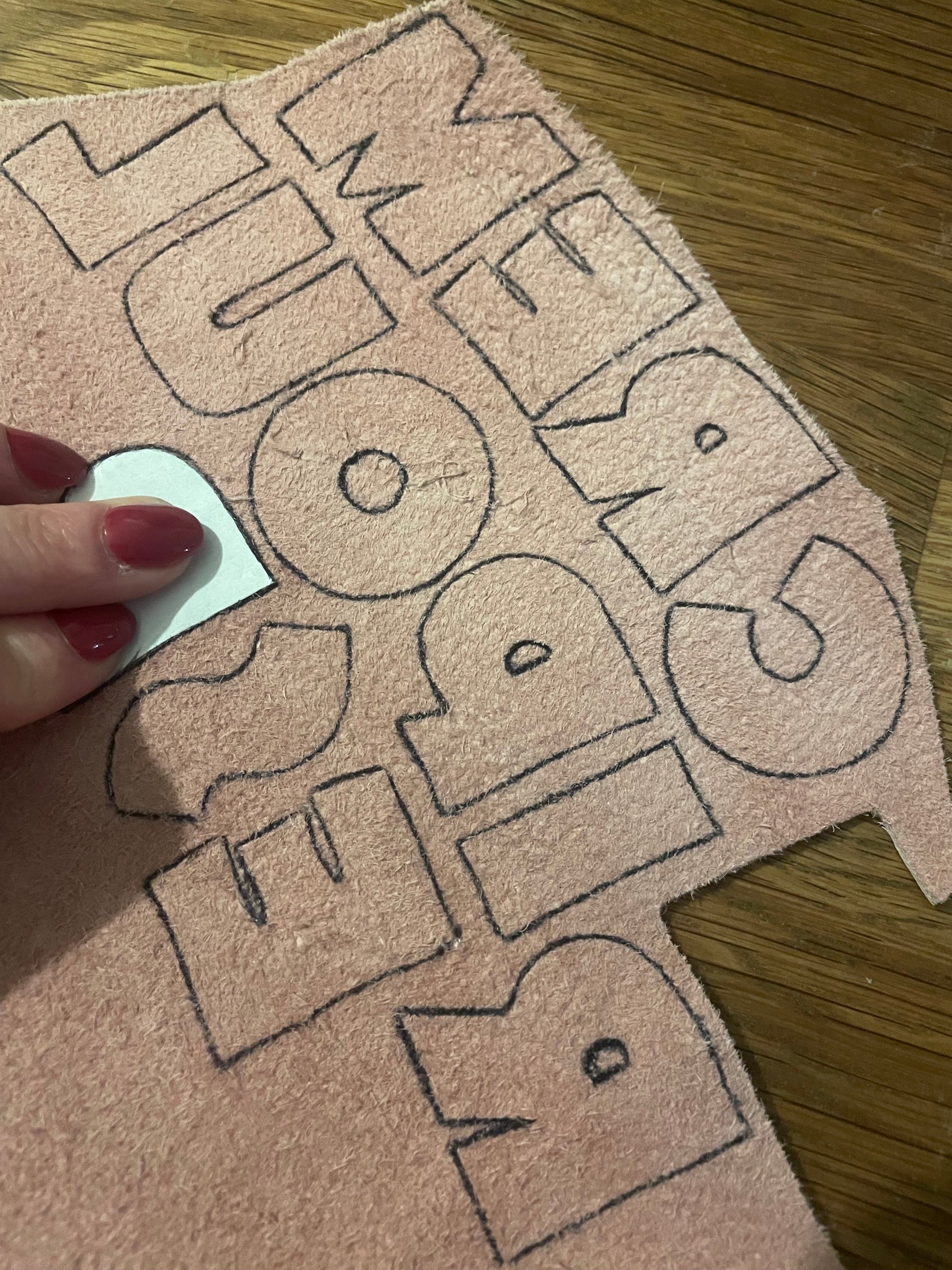 Détail formation des lettres en cuir rose avec pochoir