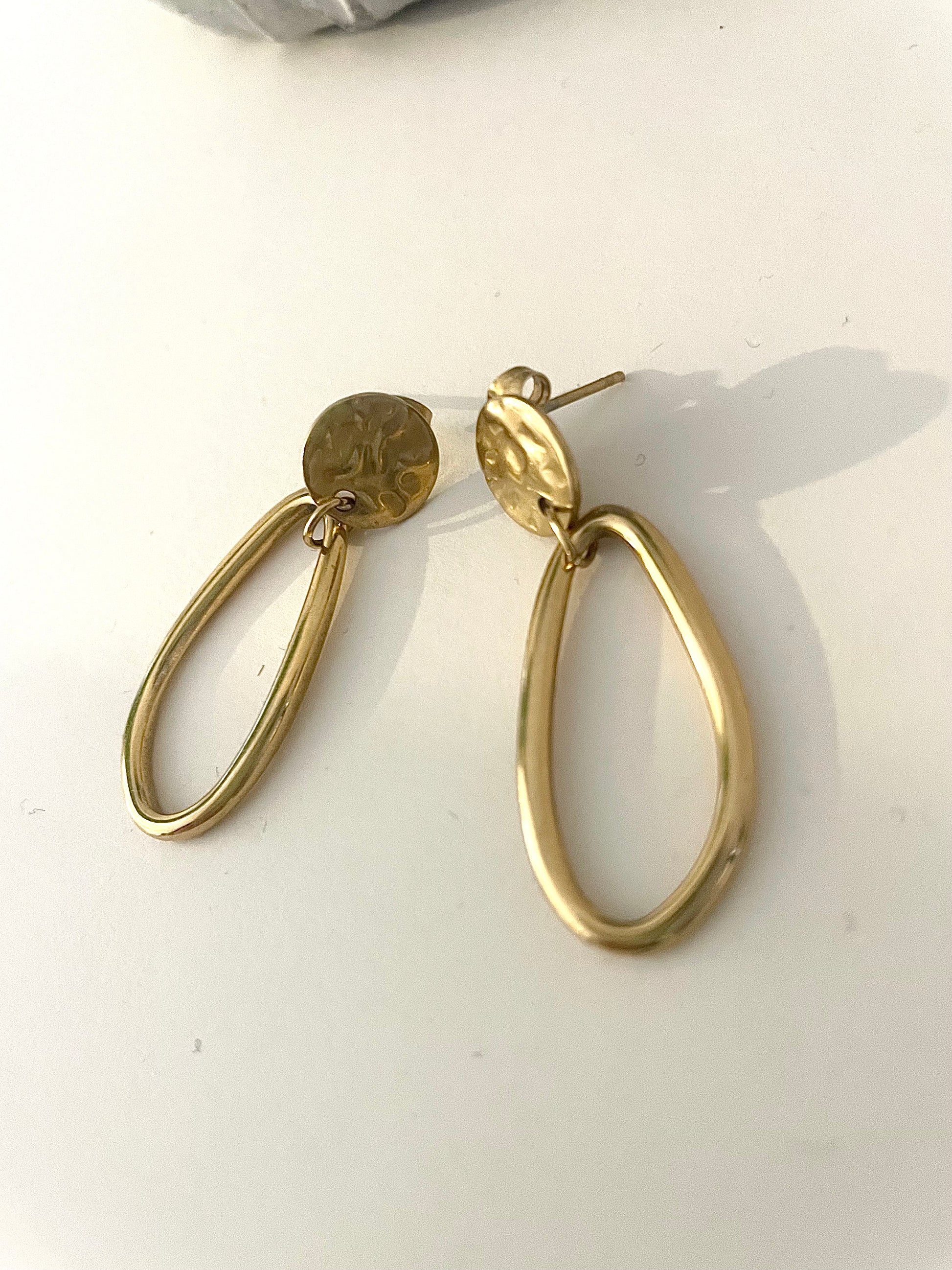 Boucles doré rond martelé et ovale pendant fond blanc