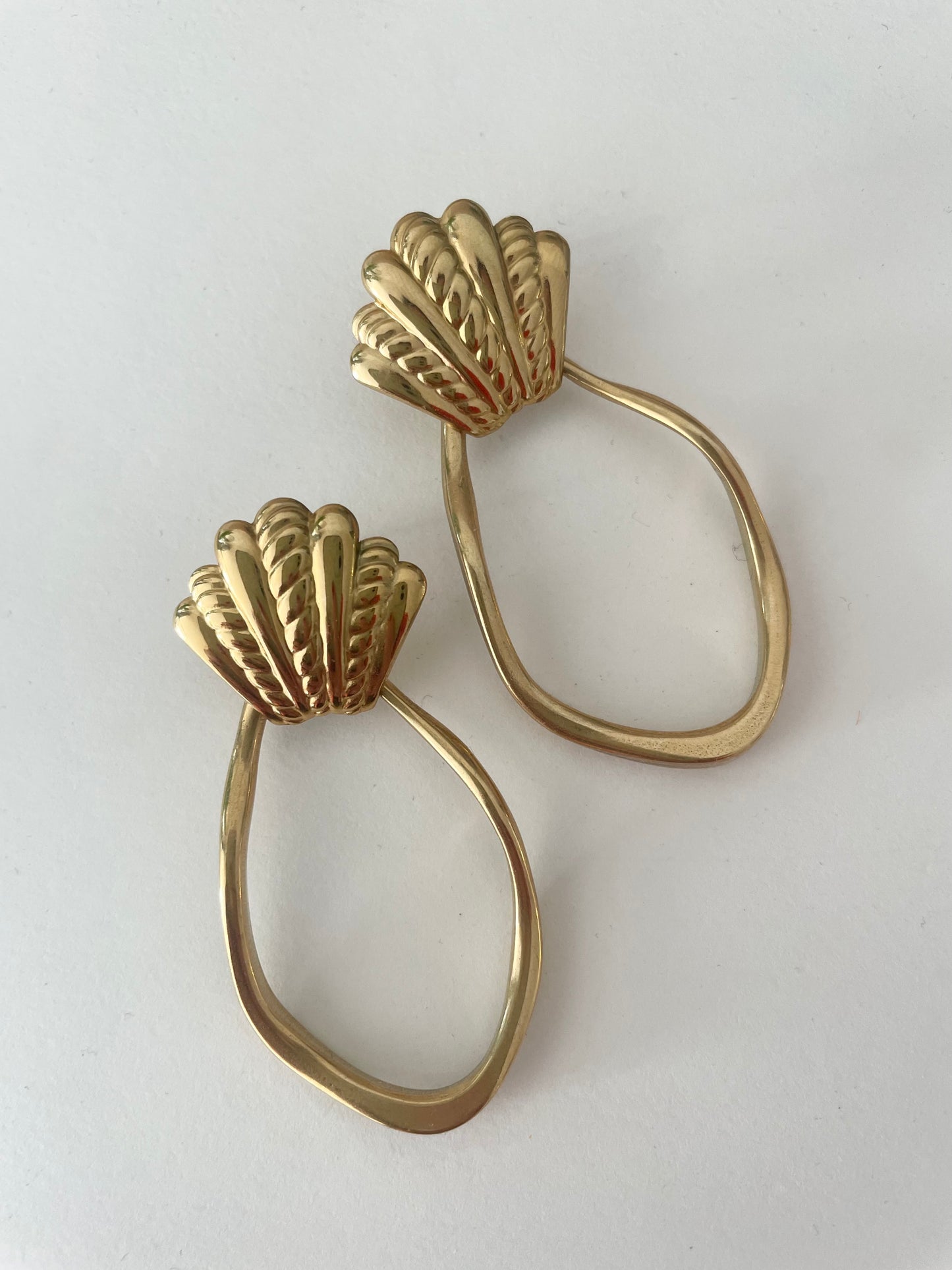 vue d'ensemble grosses boucles coquillage et pendentif asymétrique doré fond blanc