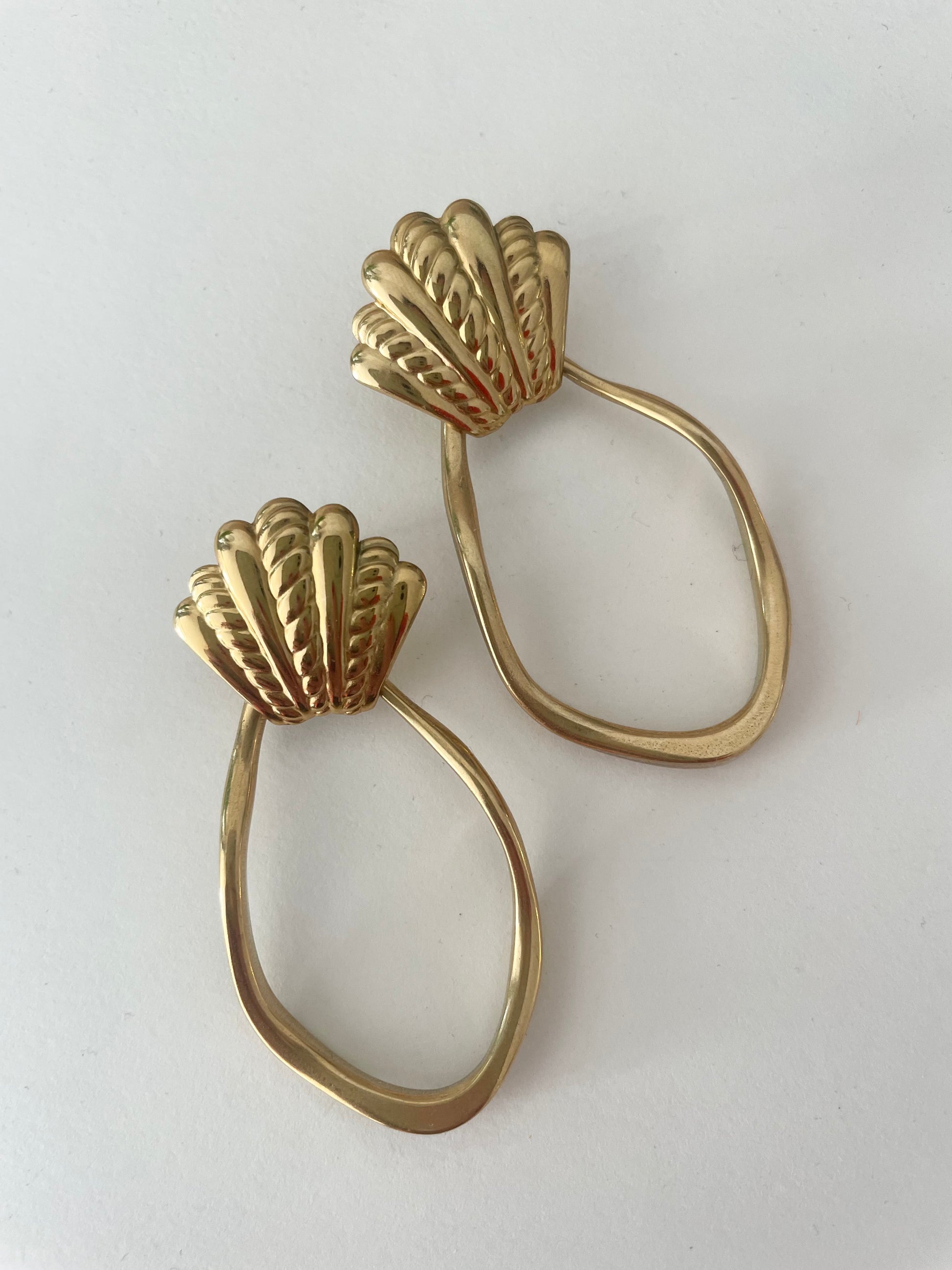 vue d'ensemble grosses boucles coquillage et pendentif asymétrique doré fond blanc