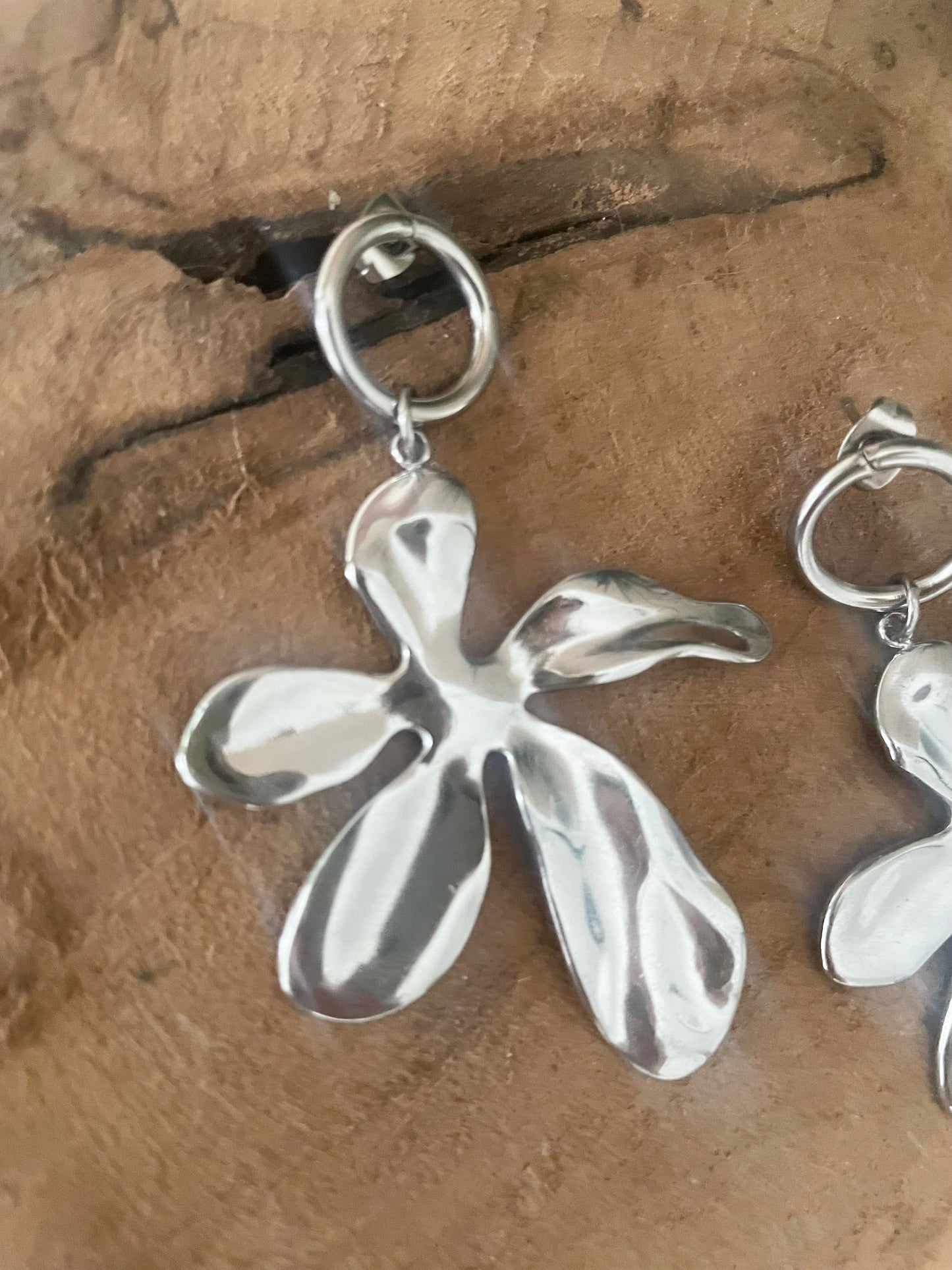 Détail gros plan boucles gros pendentif fleur acier inox argent