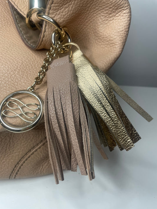Pompon frange Célestine porté sur sac à main grigri bijou de sac en cuir doré et beige