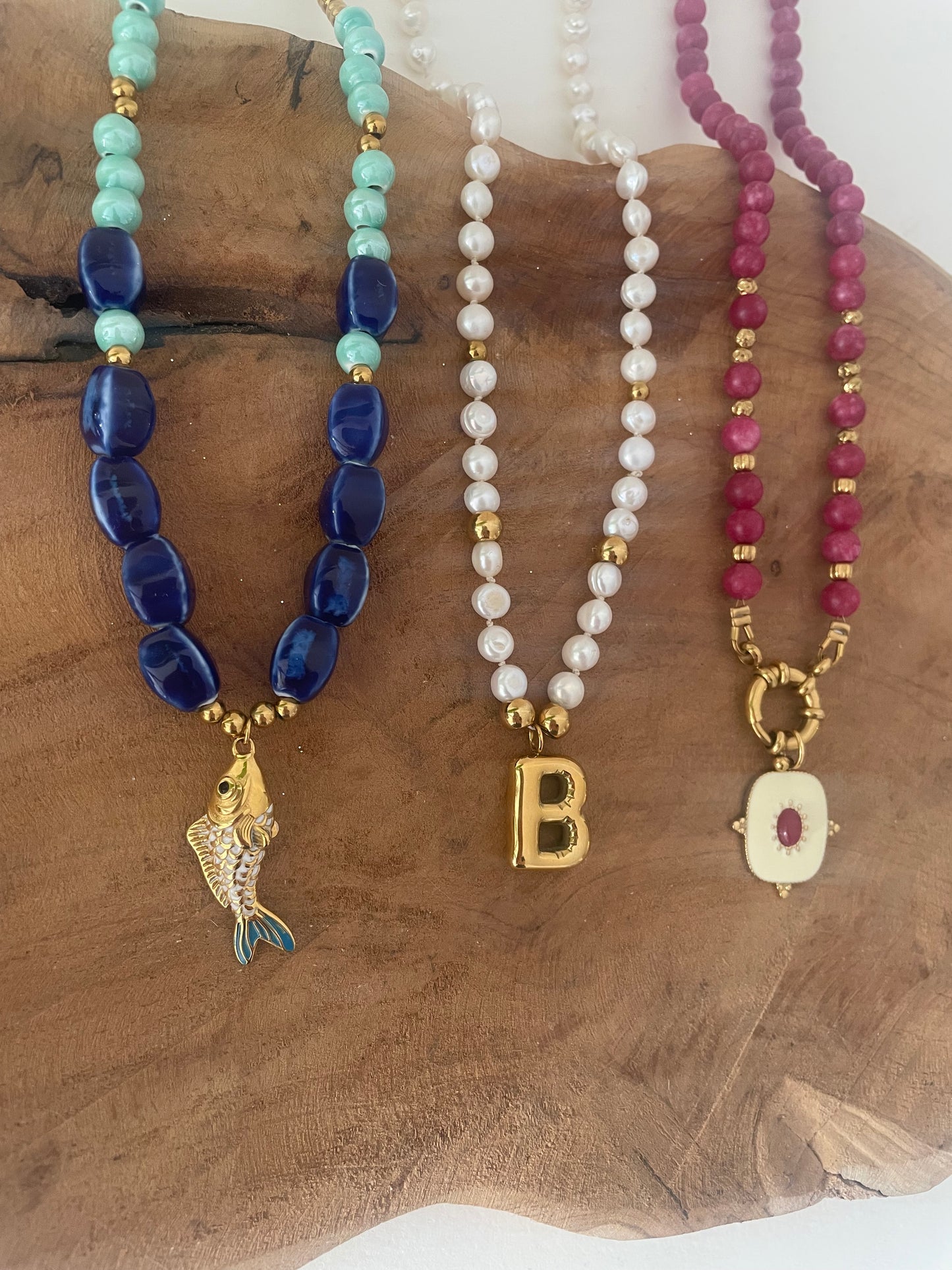 présentation 3 colliers perles naturelles sur fond bois bleu, ivoire et rose framboise fait main france