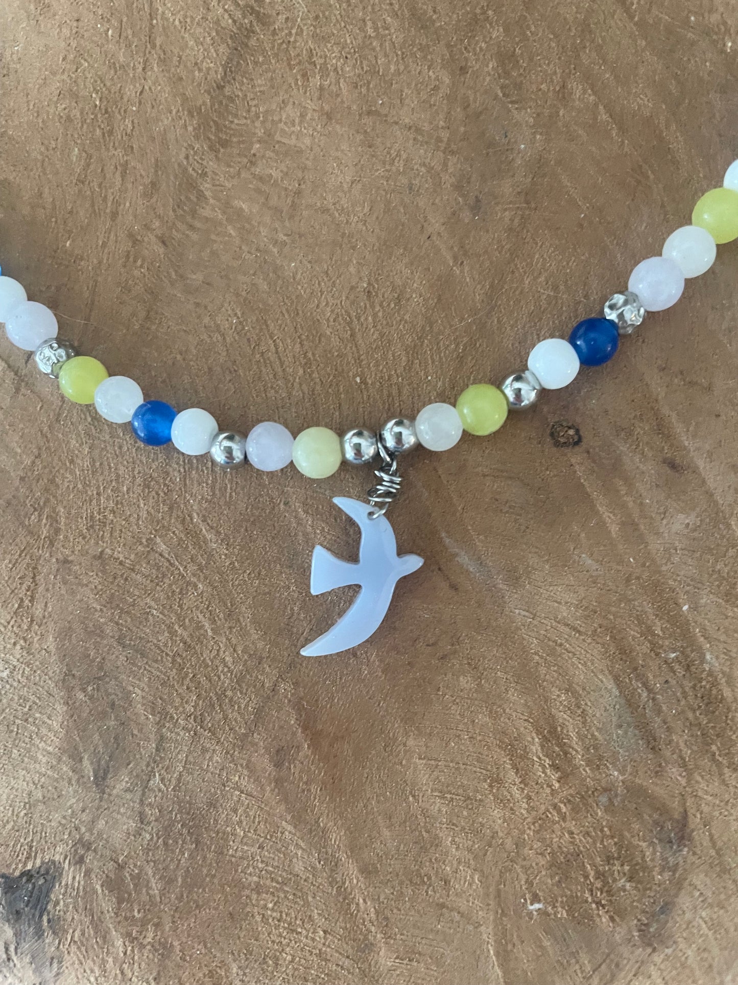 Gros plan breloque bleu ciel bracelet liberté et pierres naturelles 