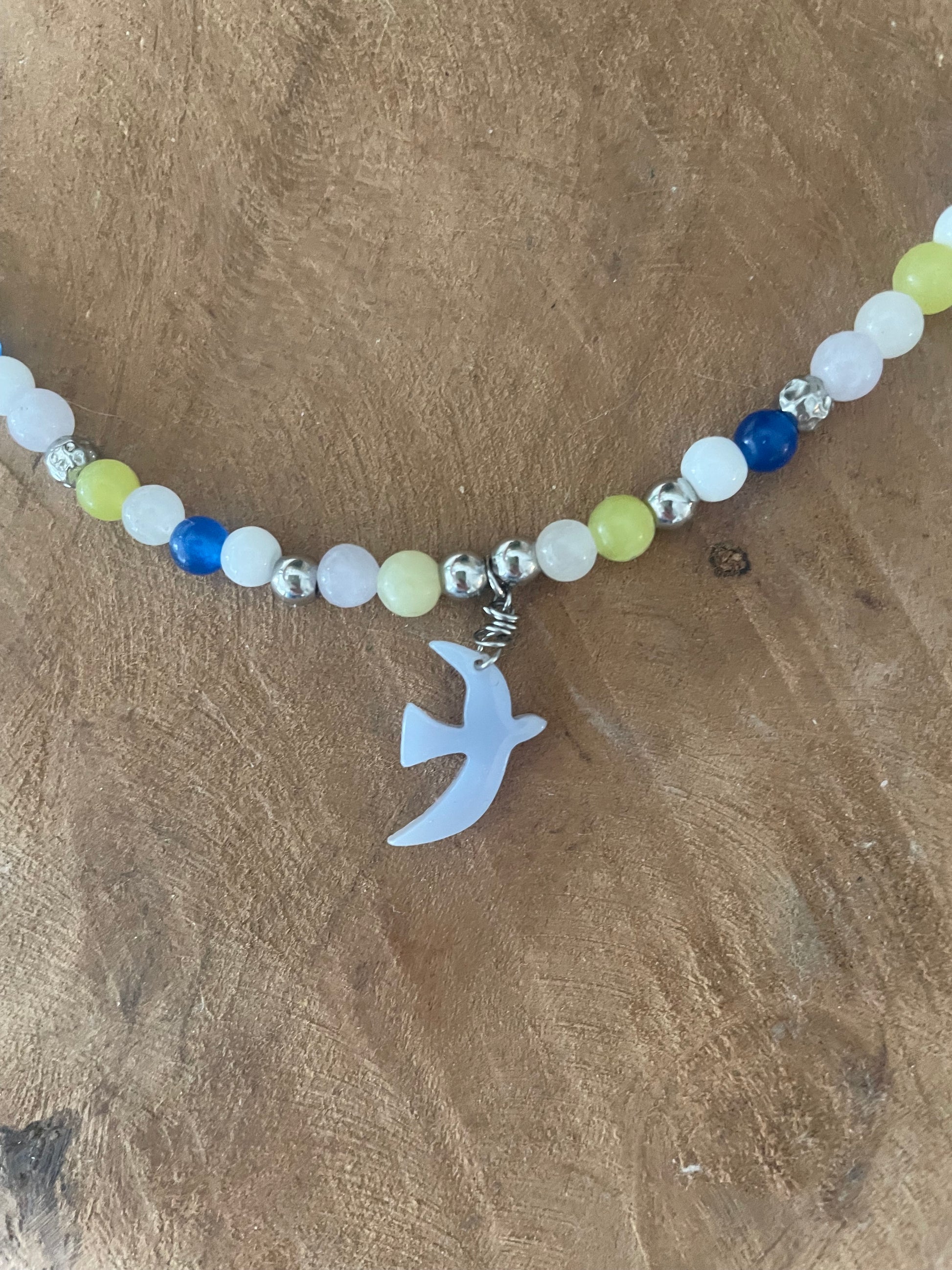 Gros plan breloque bleu ciel bracelet liberté et pierres naturelles 