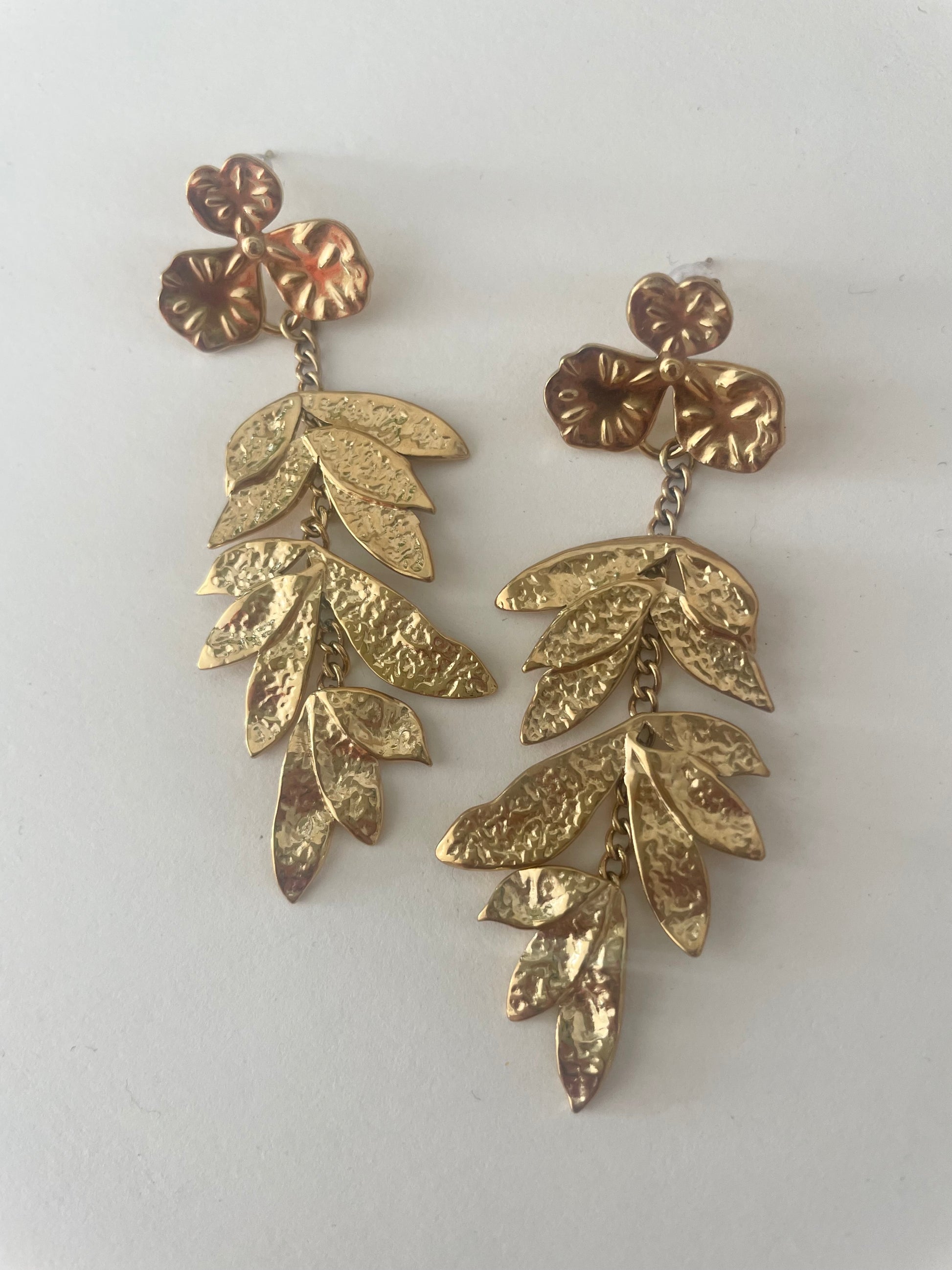 Boucles d'oreilles feuilles zoom sur fond blanc acier inox doré
