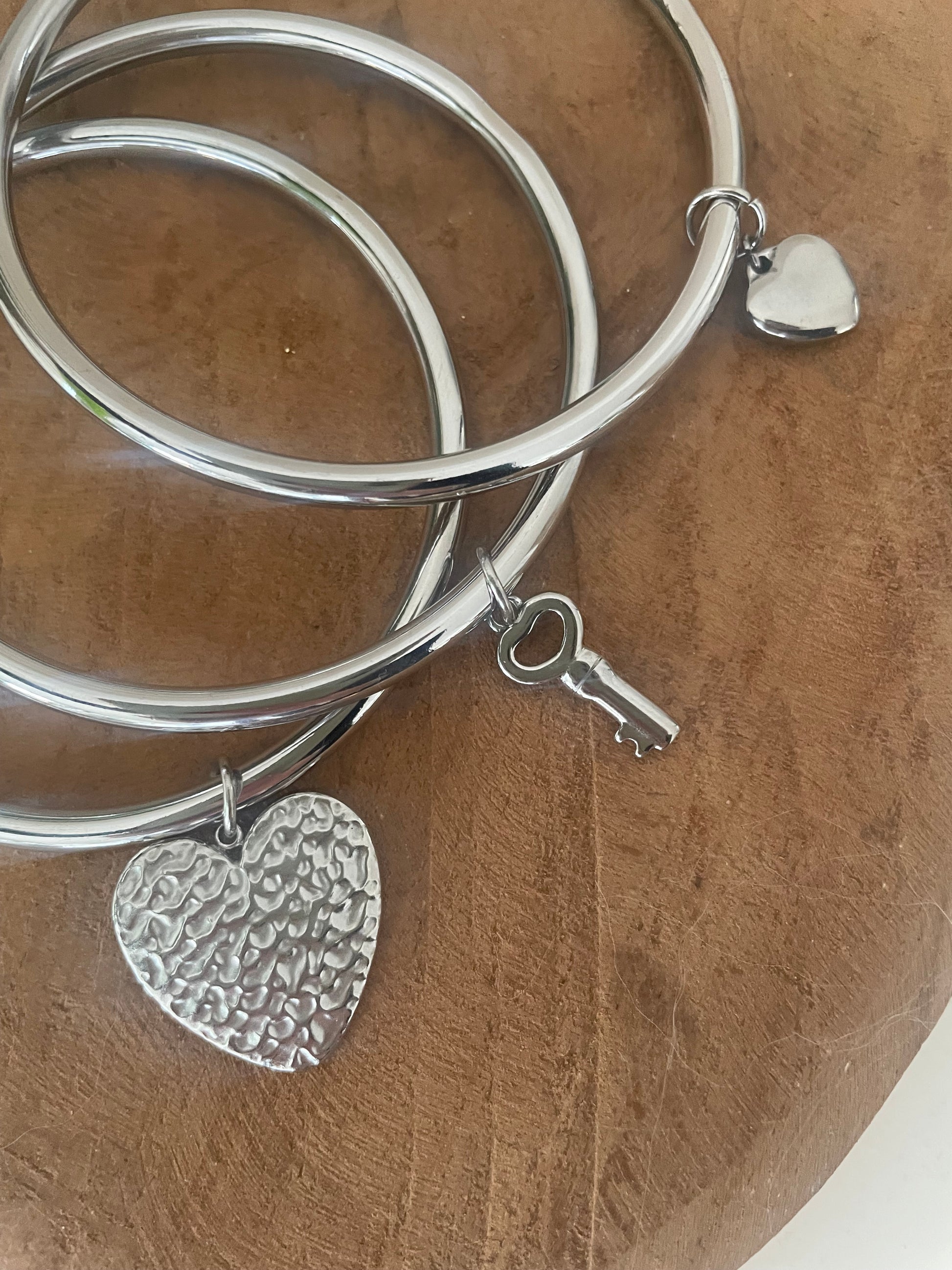 Bracelets joncs argentés portés au poignet look accumulation fait main