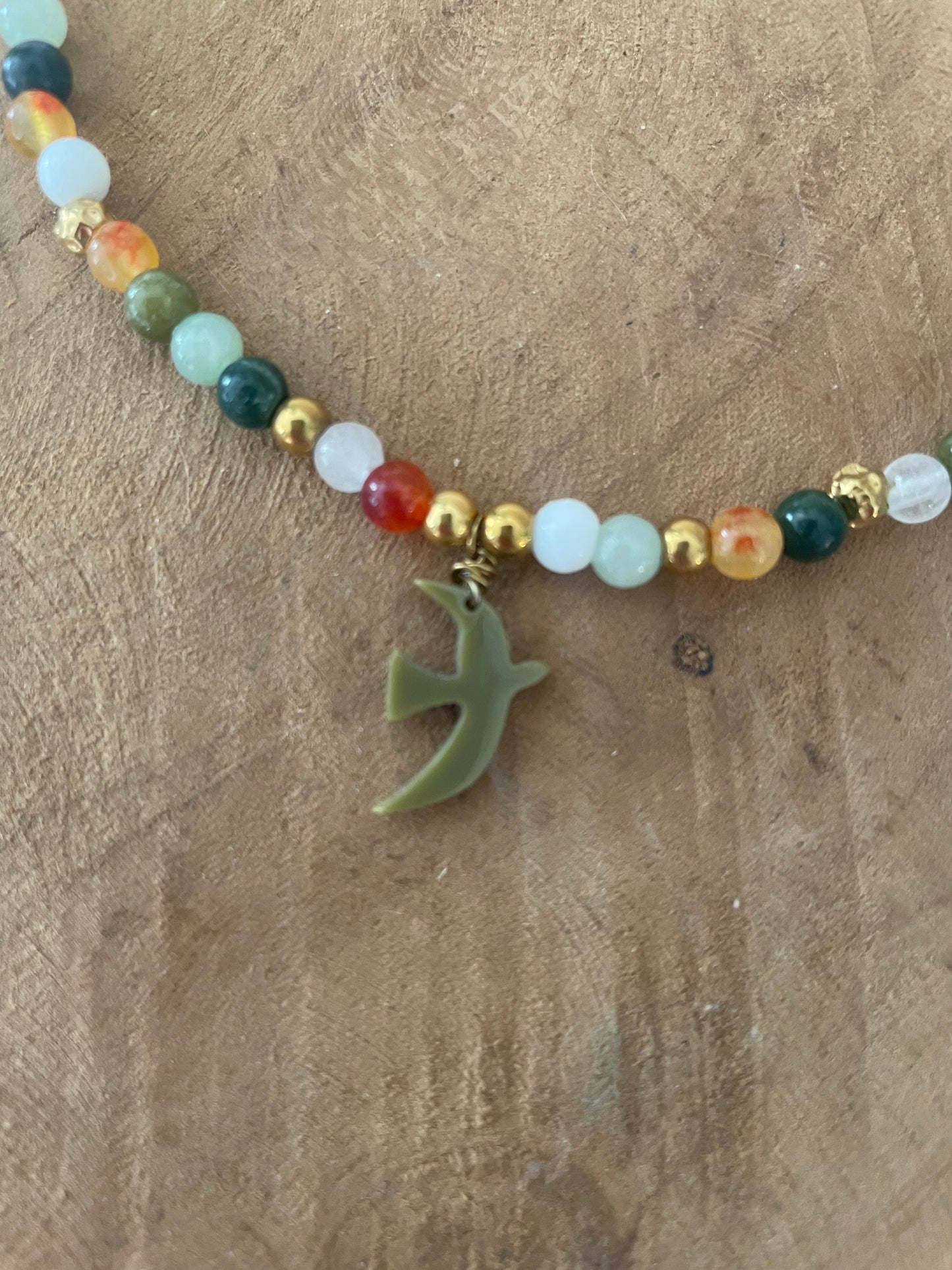 Zoom gros plan bracelet breloque ooseau kaki et pierres naturelles vert orange